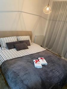 a bedroom with a bed with two pillows on it at Pannonica Apartman B in Tuzla