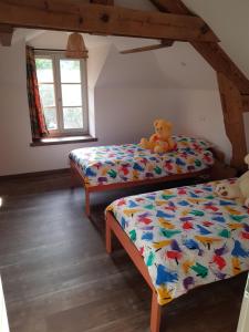 的住宿－Le moulin de la Chaîrâ，一间卧室设有两张床,床上配有泰迪熊