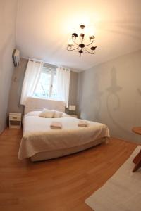 a bedroom with a large bed and a chandelier at Hostel Nina Mostar in Mostar