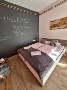 1 dormitorio con 1 cama con pizarra en la pared en Apartment GREEN&URBAN, en Celje