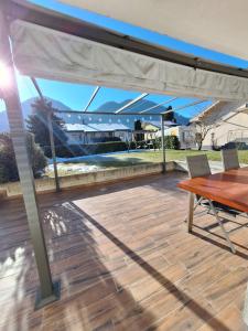 a patio with a wooden table and a white canopy at Apartment GREEN&URBAN in Celje