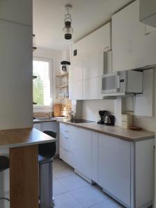 uma cozinha com armários brancos e uma bancada em Chambre privée dans magnifique appartement calme em Paris