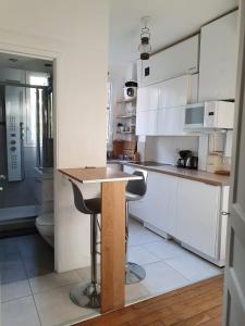 cocina con armarios blancos y encimera de madera en Chambre privée dans magnifique appartement calme en París