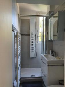 uma pequena casa de banho com um chuveiro e um lavatório. em Chambre privée dans magnifique appartement calme em Paris