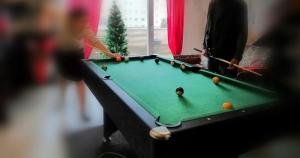 a woman playing a game of pool on a table at SeaHaven in Saint-Brieuc