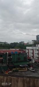 ein grünes Gebäude auf einem Parkplatz neben Gebäuden in der Unterkunft hotel seri liny in Kuching