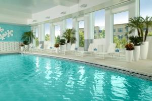 a pool in a hotel with white chairs and tables at Atlanta Airport Marriott Gateway in Atlanta