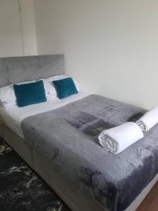 a bed with blue and white pillows on it at Tudors eSuites Budget Studio Apartment in Birmingham