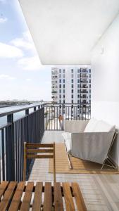 uma varanda com um sofá e um banco num edifício em Canal view 3 bedroom holiday home with balcony em Abu Dhabi