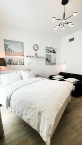 um quarto branco com uma cama grande e uma ventoinha de tecto em Canal view 3 bedroom holiday home with balcony em Abu Dhabi