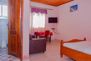 1 dormitorio con cama, sofá y mesa en COMPLEXE GROUPE NJAYOU SARL-U (CGN HOTEL), en Mapara