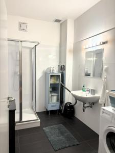 a white bathroom with a sink and a shower at Casa Nostra - Ruhige Stadtwohnung mit Balkon in Vienna