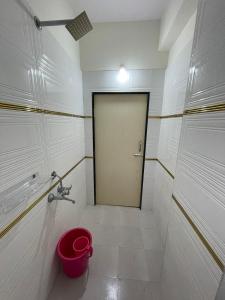 a bathroom with a door and a red bucket at Nirvana Home Stay in Visakhapatnam +28 photos