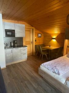 a bedroom with a bed and a kitchen with a table at Moabauer in Wagrain