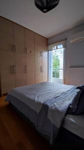 Un dormitorio con una cama grande y una ventana en Seaside Haven - Alimos, en Atenas