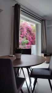 mesa y sillas en una habitación con ventana en Seaside Haven - Alimos, en Atenas