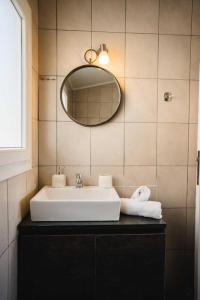 W łazience znajduje się umywalka i lustro. w obiekcie Our Luxury Houses - Suites w mieście Palaión Tsiflíkion