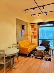 a living room with a yellow couch and a table at Regal Residences At Berjaya Times Square in Kuala Lumpur