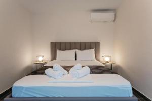 sypialnia z łóżkiem z dwoma ręcznikami w obiekcie Our Luxury Houses - Suites w mieście Palaión Tsiflíkion