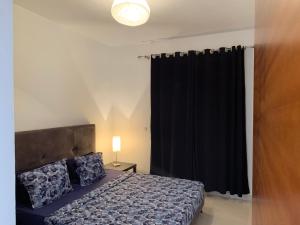 um quarto com uma cama e uma cortina preta em charmant appartement a oran gambetta pour famille em Orã