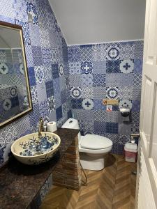 een blauwe en witte badkamer met een wastafel en een toilet bij English owned Homestay and Yoga in Chalong 