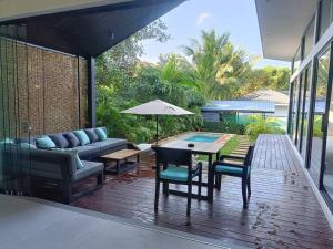 un patio con sofá, mesa y sillas en Villa Noon, en Hinkong