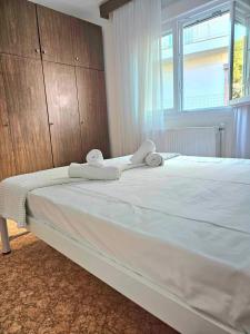 ein großes weißes Bett mit Handtüchern darüber in der Unterkunft Villa Christina in Eleftheroúpolis