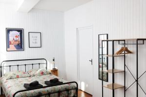 Le Studio de la Bastide - Classé 2 étoiles - Libourne في ليبورن: غرفة نوم مع سرير ورف كتاب