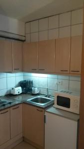 a kitchen with a stove top oven and a microwave at Apartaments Els Avets in Pas de la Casa