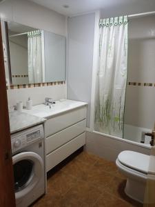 a bathroom with a washing machine and a toilet at Playa Gandia, Iris, piscina AA y WiFi in Gandía