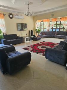 una gran sala de estar con sofás y una alfombra en B-MORE COMFORT STAY en Boma la Ngombe