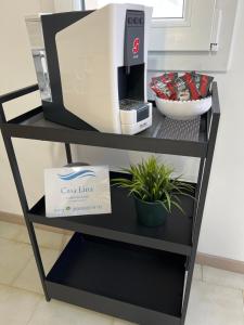 a black shelf with a coffee maker and a plant at Casa Lina in Punta Secca