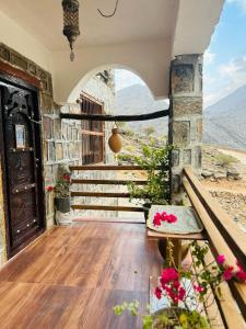 a house with a balcony with a view of the mountains at Guest house baldsayt in Bilād Sayt