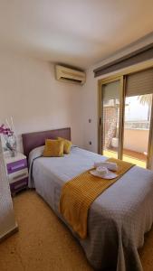 a bedroom with a large bed and a window at Pension Colón in San Juan de Alicante