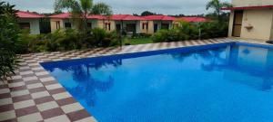 a large blue swimming pool in front of a house at Red Villa Hotel in Sasan Gir