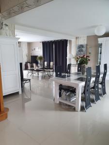 a dining room with a white table and chairs at Le logis du marais in Les Magnils-Reigniers