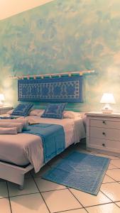 Un dormitorio con una cama grande y una pared con nubes en Casa del Campanil en Alghero