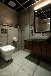 a bathroom with a toilet and a sink at Luxo Kochi in Ernakulam