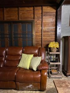 a brown leather couch sitting in a living room at Cozycomo Chiang Dao - Pha Mok in Amphoe Chiang Dao