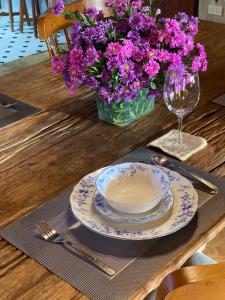 une table avec une plaque et un vase de fleurs violettes dans l'établissement Cozycomo Chiang Dao - Pha Mok, à Amphoe Chiang Dao
