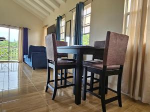 a dining room table and chairs in a living room at Royal Escape - 2 in Anse La Raye