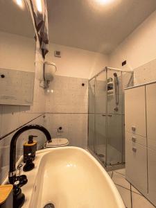 y baño blanco con bañera y ducha. en Casa del Campanil en Alghero