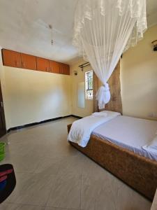 Schlafzimmer mit einem Bett mit Moskitonetz in der Unterkunft B-MORE COMFORT STAY in Boma la Ngombe