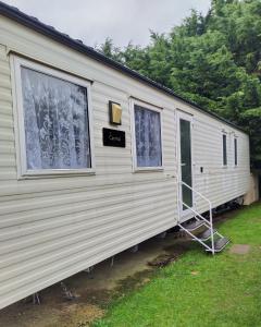 a mobile home with a door and two windows at Carnival Our lovely home from home in Great Yarmouth