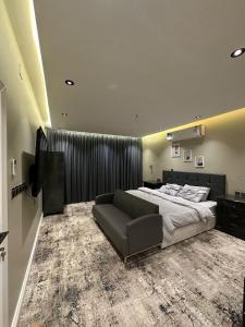 - une grande chambre avec un lit et un canapé dans l'établissement أجنحة لافينا الخاصة, à Yanbu