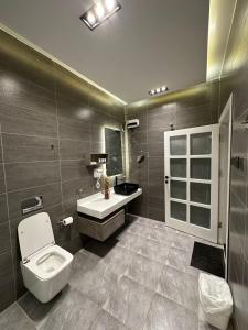 a bathroom with a toilet and a sink at أجنحة لافينا الخاصة in Yanbu