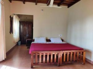 1 dormitorio con 1 cama grande con manta roja en Daisy Land - Farm Stay. (Group of 4+ guests), en Cherambane