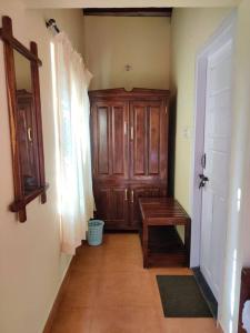 a hallway with a wooden door and a wooden table at Daisy Land - Farm Stay. (Group of 4+ guests) in Cherambane