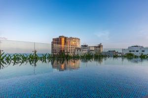 uma piscina com edifícios ao fundo em Taiyo Hotel & Apartment em Da Nang