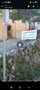 a sign that is on a wall next to a street at Apartments and rooms Roberto B. in Valun